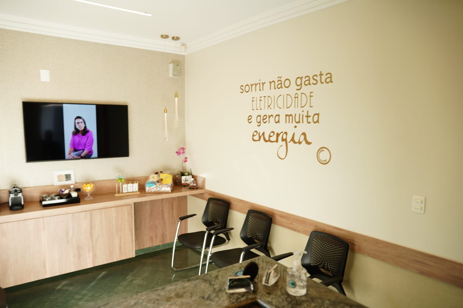 Recepção da Cotta Odontologia com poltronas claras e parede verde